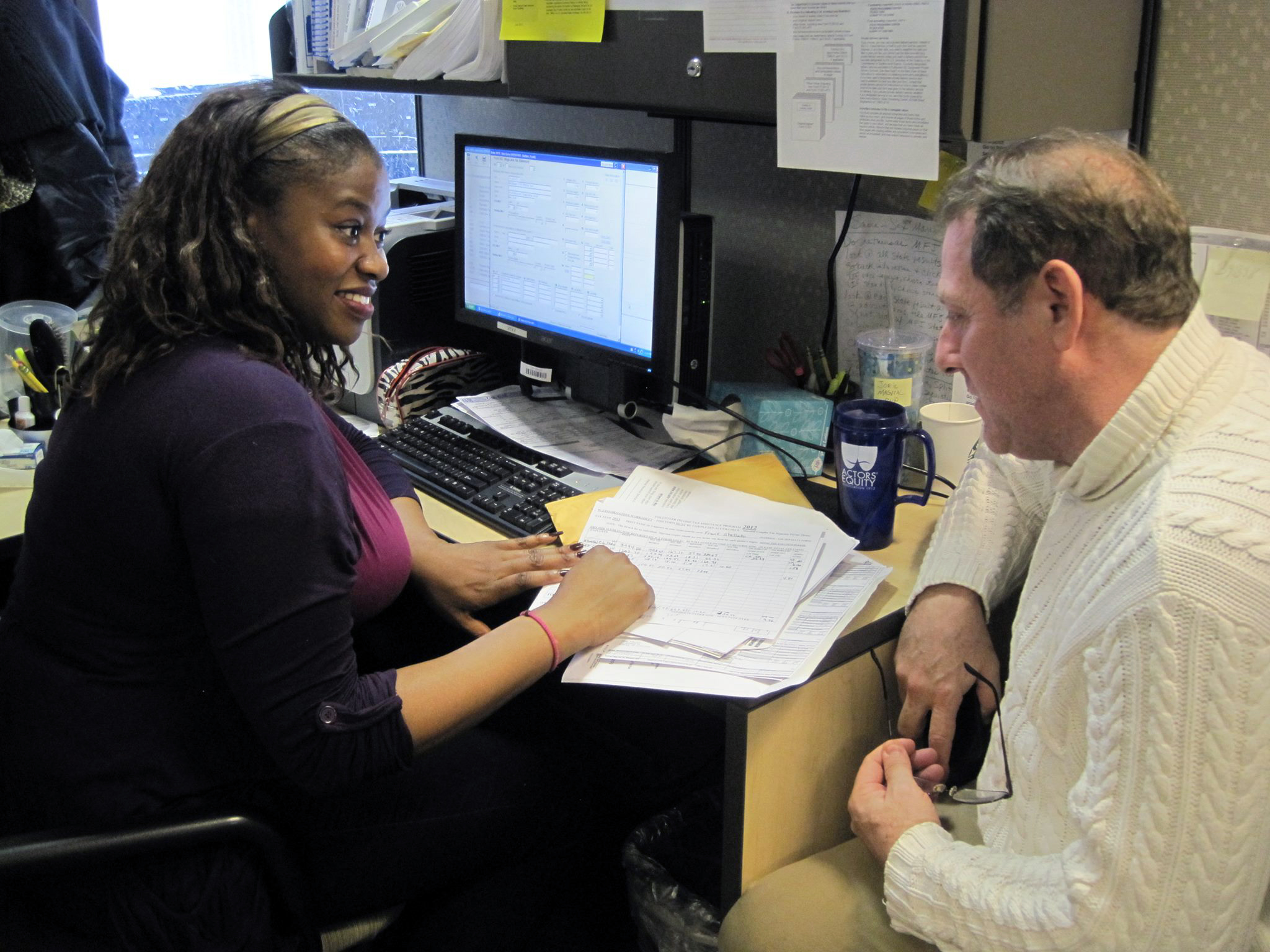 Equity member Nneoma Nkuku helps prepare taxes for fellow member Frank Stellato on VITA's opening day, 2014